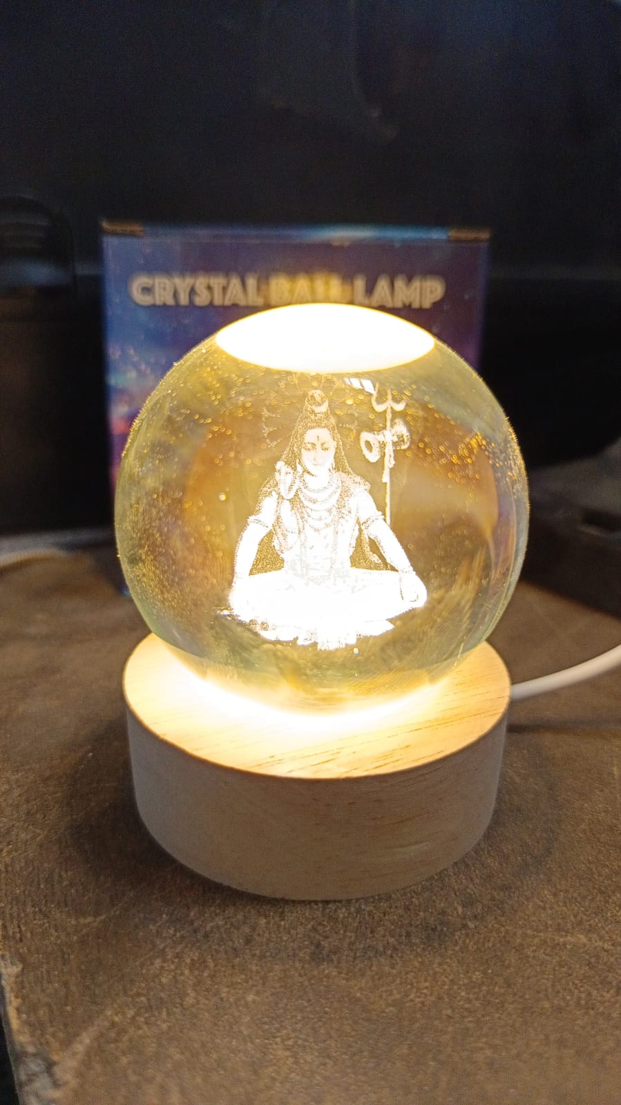The 3D Crystal Ball Lamp from shown from an alternative angle, illuminating a dark room.
